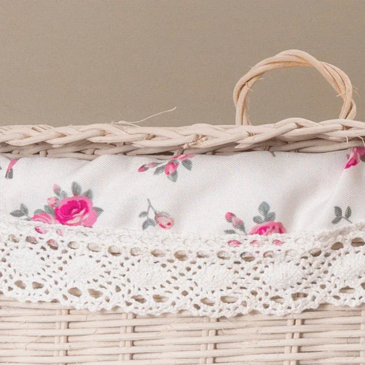 Wicker basket with white floral fabric liner and crochet lace trim in a neutral setting