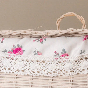 Wicker basket with white floral fabric liner and crochet lace trim in a neutral setting