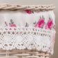 Close-up of a wicker basket with floral fabric and white crocheted lace trim