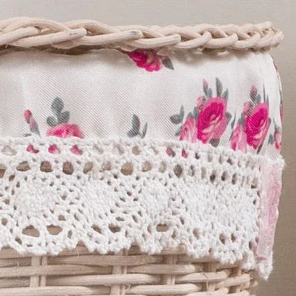 Close-up of a wicker basket with floral fabric and white crocheted lace trim