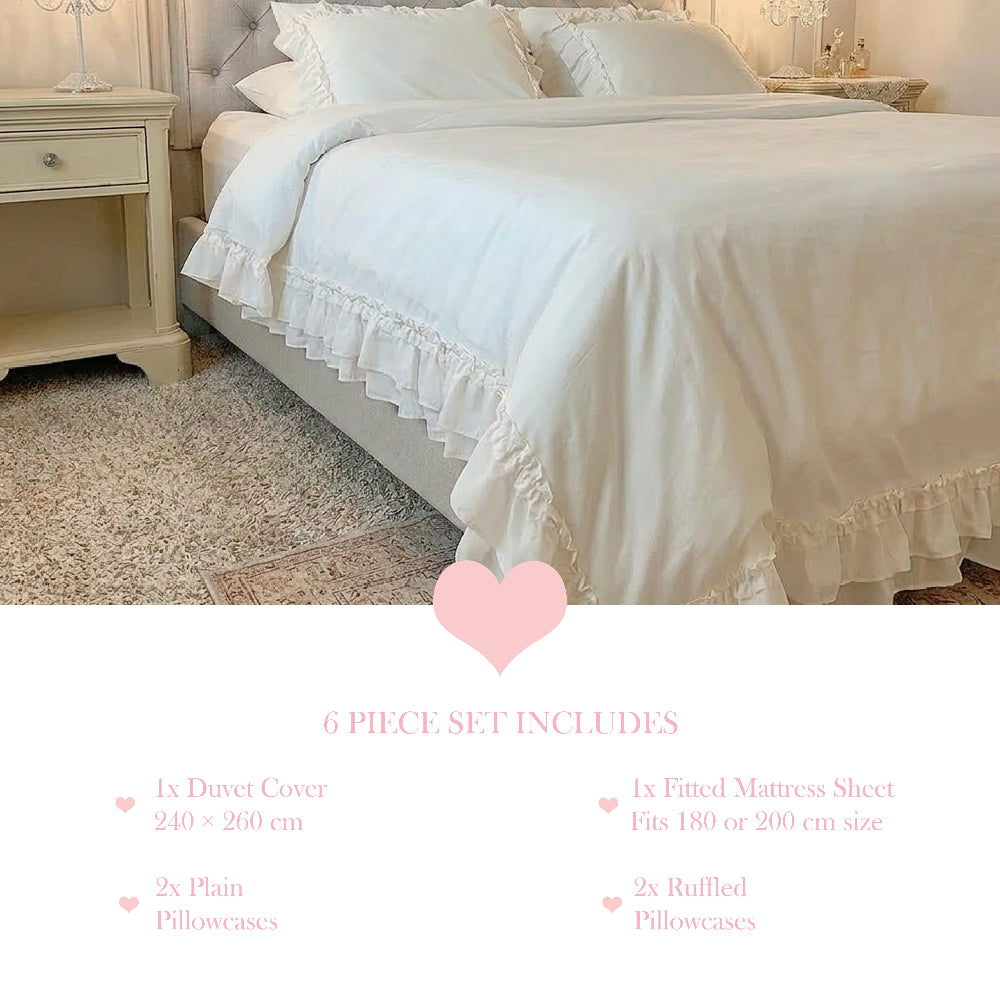 White ruffled bedding set on a bed with a side table and text listing a 6 piece set including duvet and pillowcases.