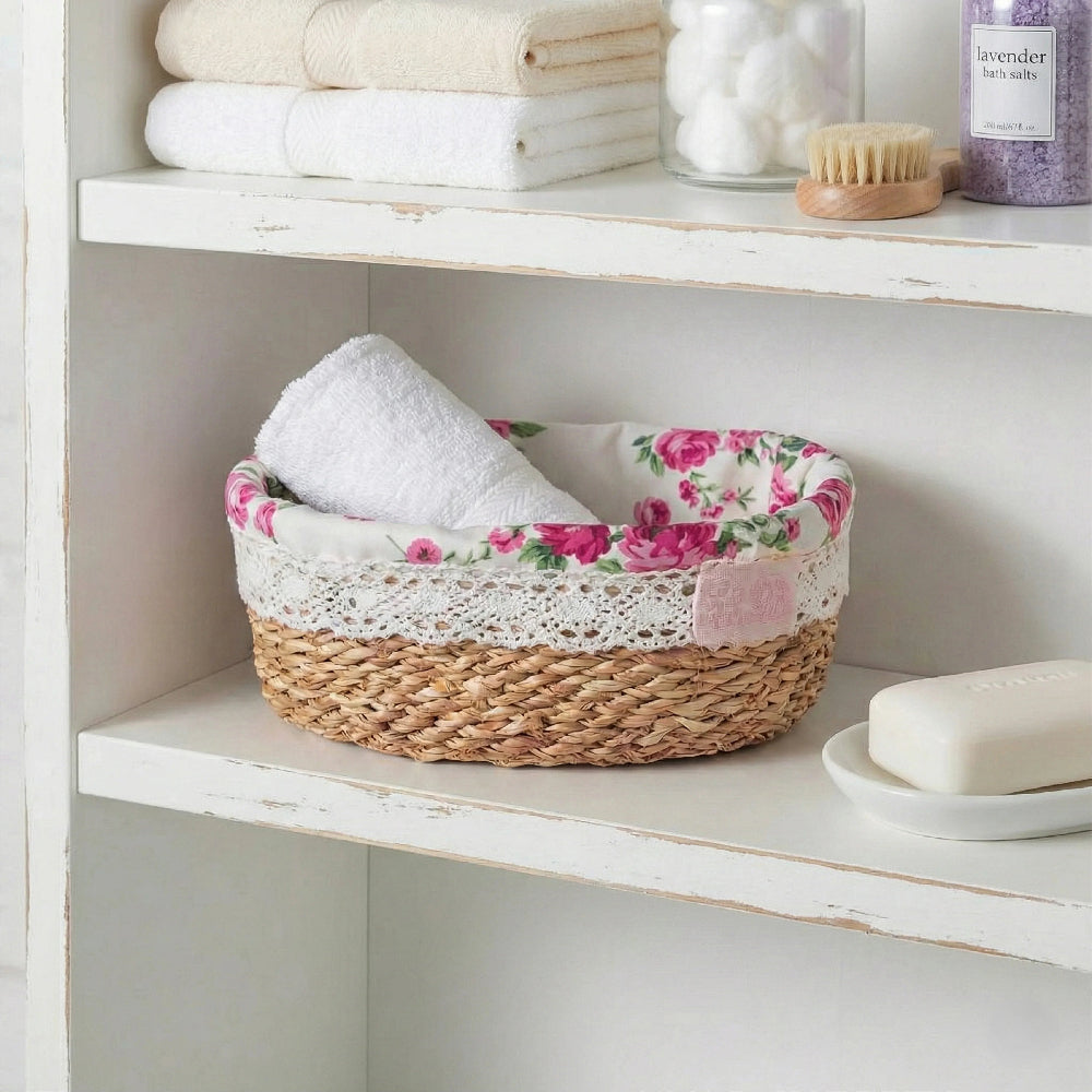 Floral-patterned basket with rolled towels on a white shelf.