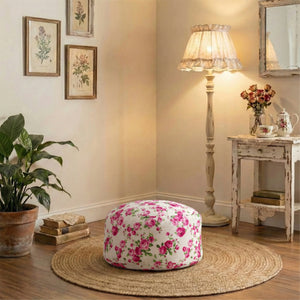 Floral ottoman in a cozy living room with a lamp and books.