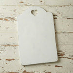White cutting board with a heart-shaped hole on a rustic wooden surface