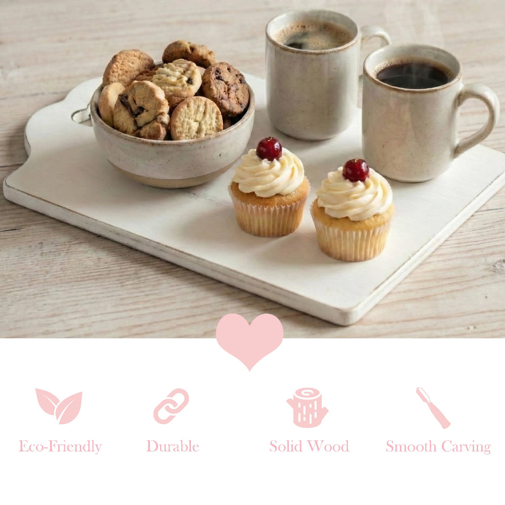Two cupcakes with cream and cherries on a white wooden board with two mugs of coffee and a bowl of cookies.