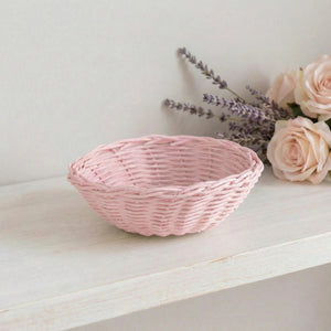 Pink woven basket on a white surface with lavender and roses.
