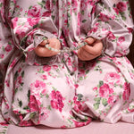 Person wearing a floral dress holding prayer beads.