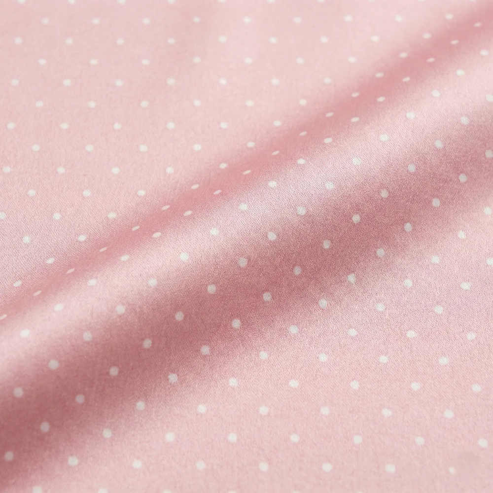 Pink fabric with small white polka dots