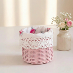 Pink wicker basket with a floral pattern on a white surface