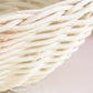 Close-up of woven white wicker basket texture against a light background