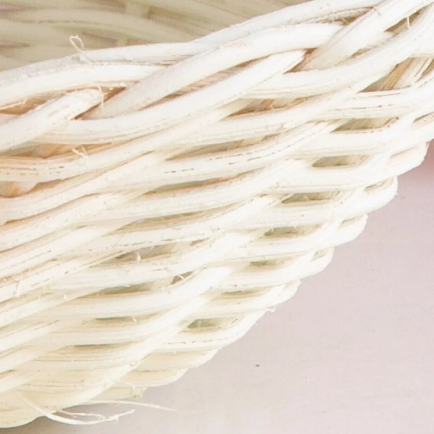 Close-up of woven white wicker basket texture against a light background