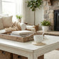 Cozy living room with a wooden coffee table, books, a cup, and a fireplace.