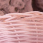 Close-up of tightly woven light pink wicker basket with natural texture