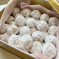 Box of kahk cookies with a pink decorative paper lining