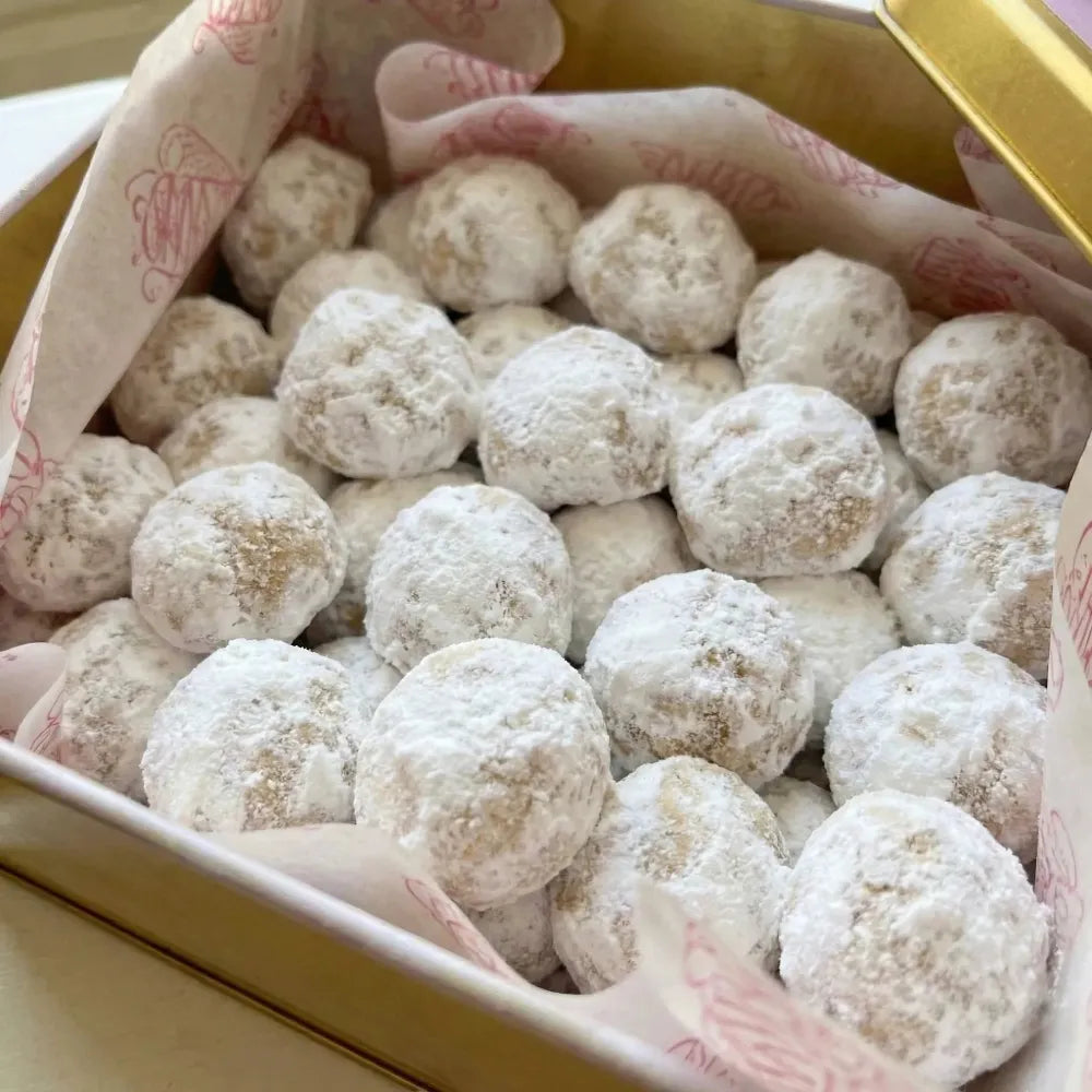Box of kahk cookies with a pink decorative paper lining