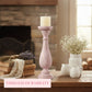 Decorative setting with a candle holder, books, and flowers on a wooden surface.