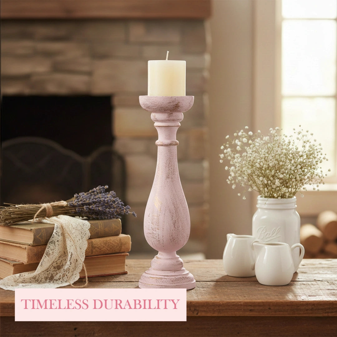 Decorative setting with a candle holder, books, and flowers on a wooden surface.