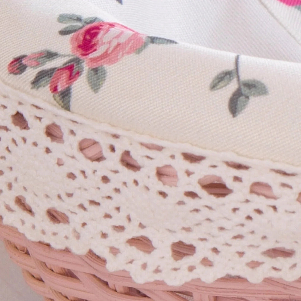 Close-up of a pink Cottage Round Wicker Basket with floral fabric and lace trim.
