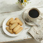 Cup of coffee with a plate of nashader cookies on a rustic wooden table.
