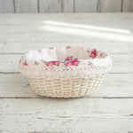 Cottage Round Wicker Basket with floral fabric lining on a wooden surface