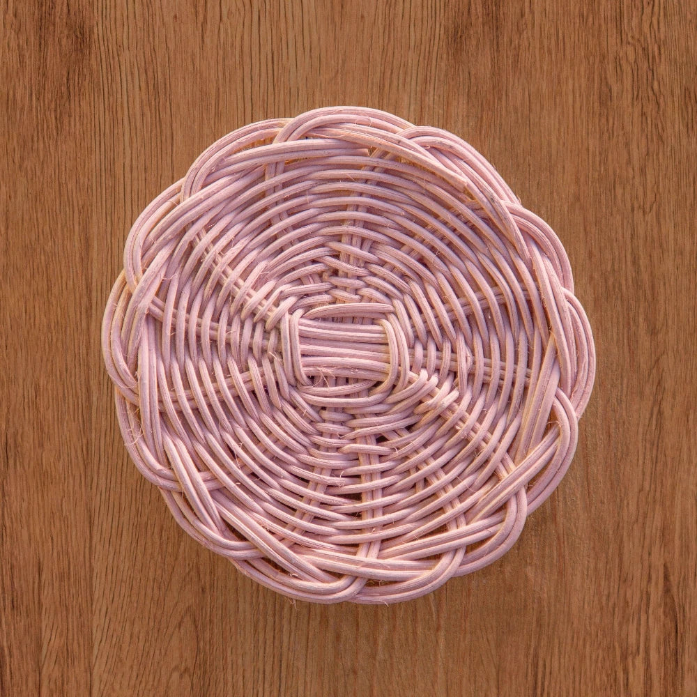 Cottage Round Wicker Coaster displayed on a wooden surface with woven wicker texture