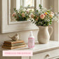 Country Charm Air Kisses Home Fragrance displayed with flowers and books on decorative shelf