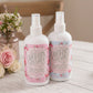 Country Charm Air Kisses Home Fragrance and Scent of Love spray bottles on wooden surface with floral accents
