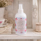 Country Charm home fragrance mist bottle on a decorative surface with floral elements.