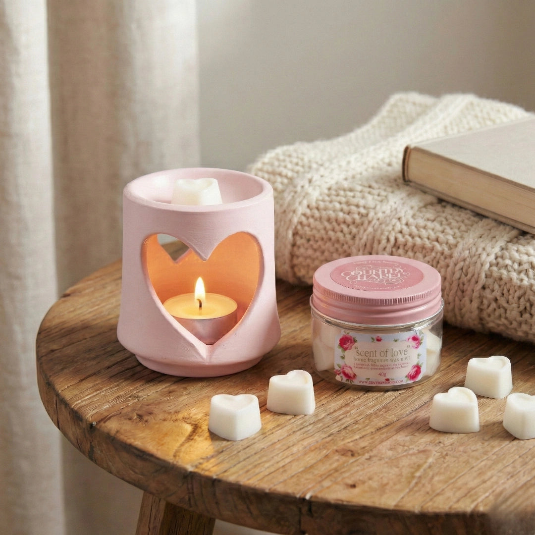 Country Charm Scent of Love home fragrance soy wax melts on a wooden table next to a pink ceramic heart burner.