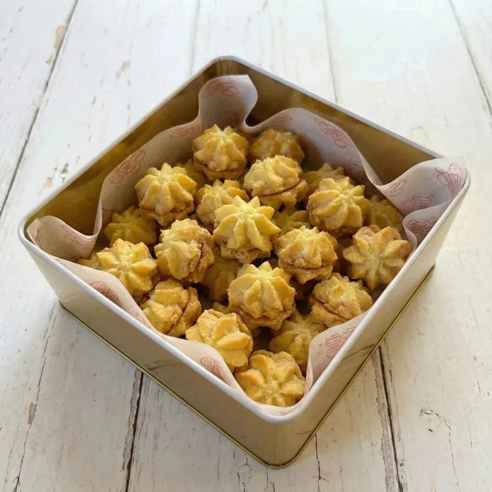 Country Charm Rosie tin box filled with Petit Four Cookies on light wooden surface