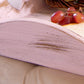 Close-up of rustic white wooden tray with red grapes, placed on beige fabric surface