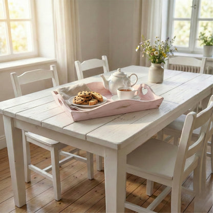 Dining room with a white table and chairs, featuring a tea set and cookies on country heart cut-out tray pale pink.