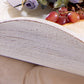 Close-up of rustic white wooden tray with red grapes and decorative purple flowers on beige fabric