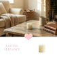 Cozy living room with a wooden table, antique-white-pillar-candle, mug, and books, featuring 'Lasting Elegance' text.