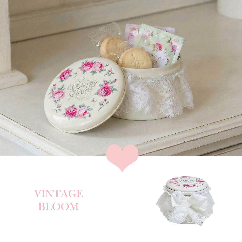 Decorative cookie tin with floral design on a white surface, featuring the brand 'Country Charm'.