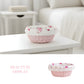 Decorative pink Cottage Round Wicker Basket on a white surface with a blurred background 