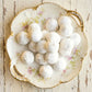 Decorative plate with white spherical kahk on a rustic wooden surface