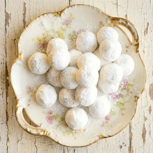 Decorative plate with white spherical kahk on a rustic wooden surface