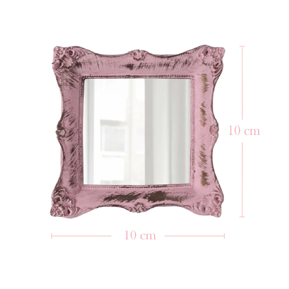 Square pink mirror with distressed ornate edges and pink dimension lines indicating 10 cm height and width.