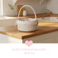 Wicker basket with floral lining on a wooden kitchen counter, with text 'Soft tones for cozy spaces'.