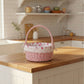 Pink wicker basket with floral lining on a kitchen counter