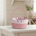 Pink wicker basket with floral lining on a white table
