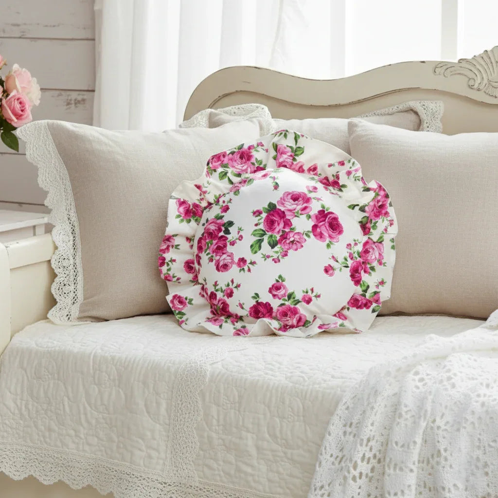 Antique white circular floral pillow with ruffled edge on a sofa