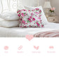 Antique white floral pillow on a bed with softness, durability, lightness, and breathability icons below.
