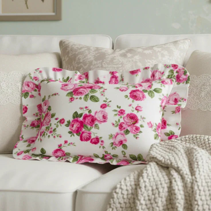Antique white rectangular floral pillow on a sofa with a soft focus background