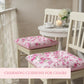 Fleur cushions on chairs with a table and decor in the background