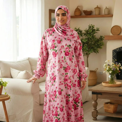 Woman wearing a pink Isdal Prayer dress and hijab in a living room setting.