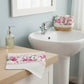 Fleur Face Towel displayed in bathroom beside sink and soap dispenser