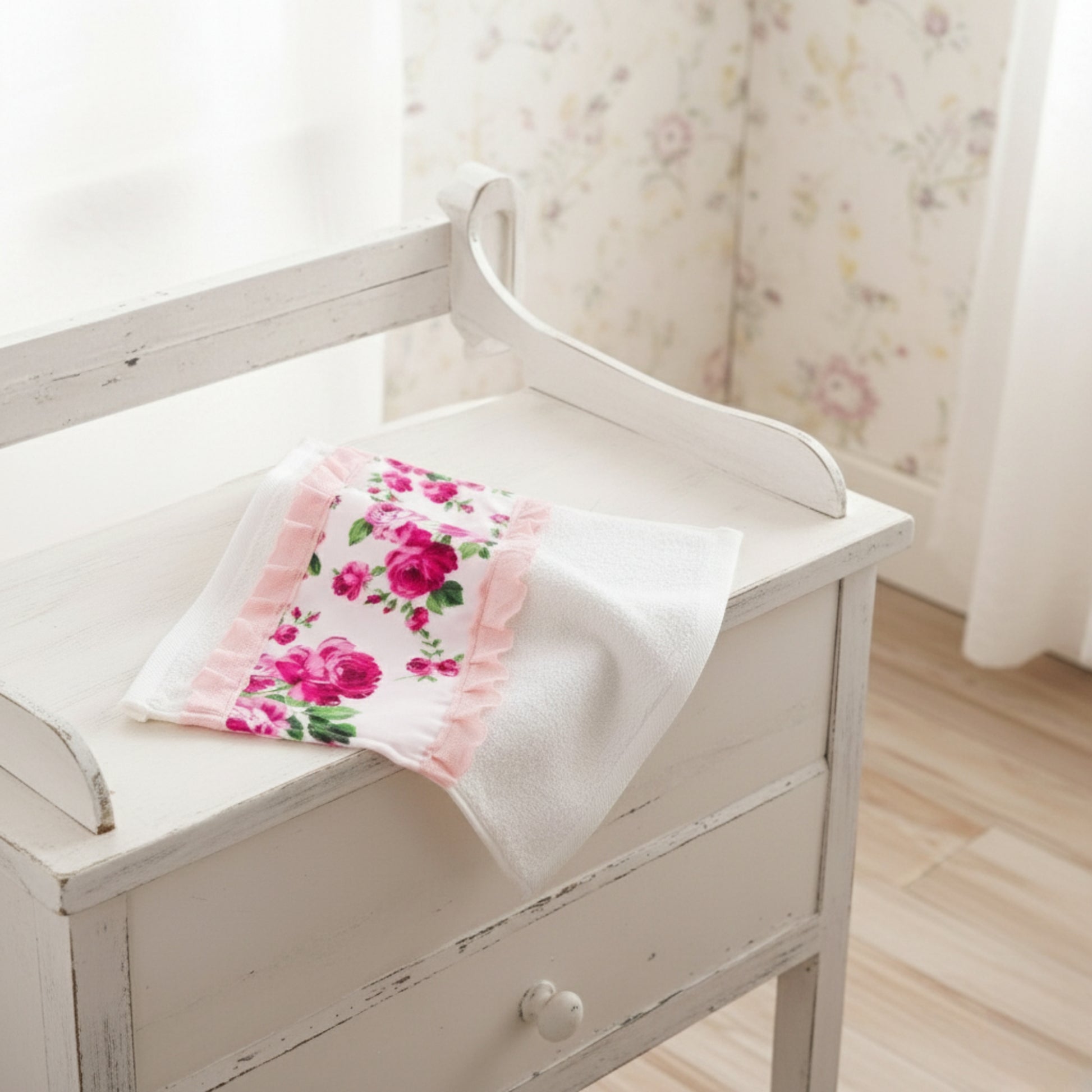Floral-patterned towel on a white wooden chair with a floral curtain in the background