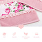 A pink face towel with a floral fleur print and lace detailing, with product details and logo